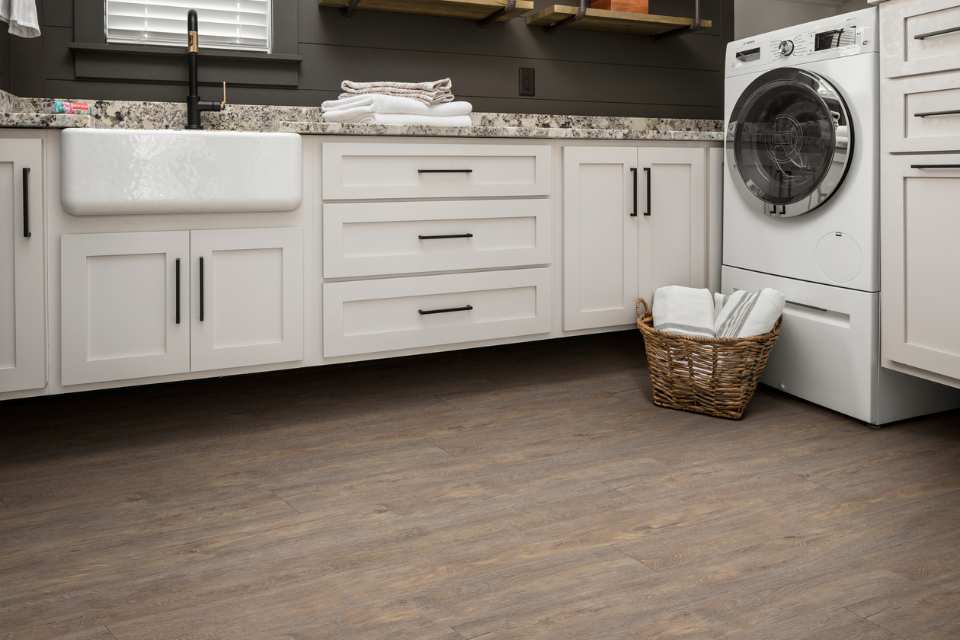 wood look luxury vinyl in white laundry room with farmhouse sink